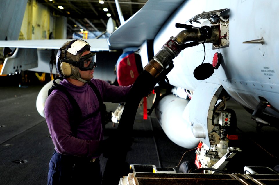 US Navy 100509-N-6604E-106 Airman Benjamin Gomez attaches a fuel hose to an aircraft in the hangar bay of the aircraft carrier USS Dwight D. Eisenhower (CVN 69)