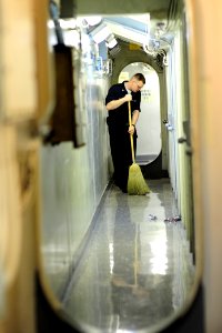 US Navy 100509-N-6604E-015 Hull Technician 3rd Class James Hampton sweeps a passageway aboard the aircraft carrier USS Dwight D. Eisenhower (CVN 69)