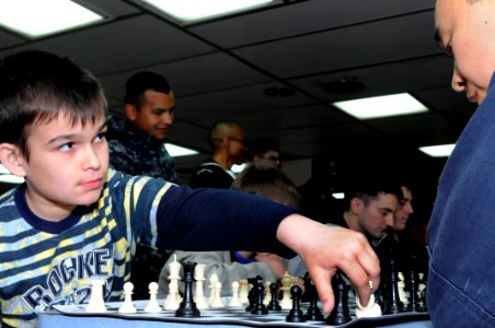 US Navy 100510-N-1675O-335 Machinist's Mate Conley Terrell plays chess with a child from Parus Nadezhdy Children's Rehabilitation Center on the mess decks aboard the U.S. 7th Fleet command ship USS Blue Ridge (LCC 19)