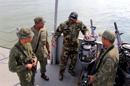 US Navy 100512-N-4205W-145 A U.S. Navy special warfare combatant-craft crewman explains the maintenance procedures of an outboard motor to members of the Brazilian Marine Corps Special Operations Battalion photo