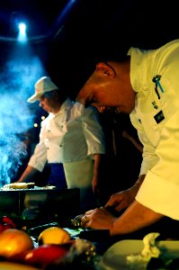 US Navy 100510-N-5716H-407 Culinary Specialist 2nd Class Edgar Tandoy slices cucumber during a cook-off between Russian and U.S. Navy sailors at Fabrika restaurant in Vladivostok, Russia photo