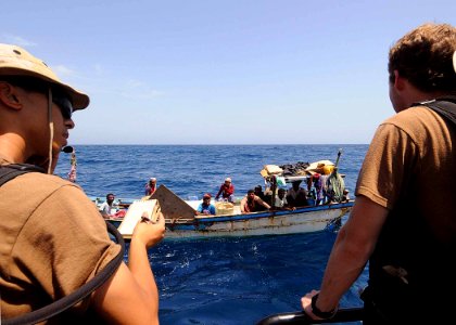 US Navy 100511-N-1082Z-058 Electronics Technician 2nd Class Patrick T. Huynh and Intelligence Specialist 2nd Class Harley M. Nelson speak with crew members of a fishing dhow while conducting maritime security operations in the photo