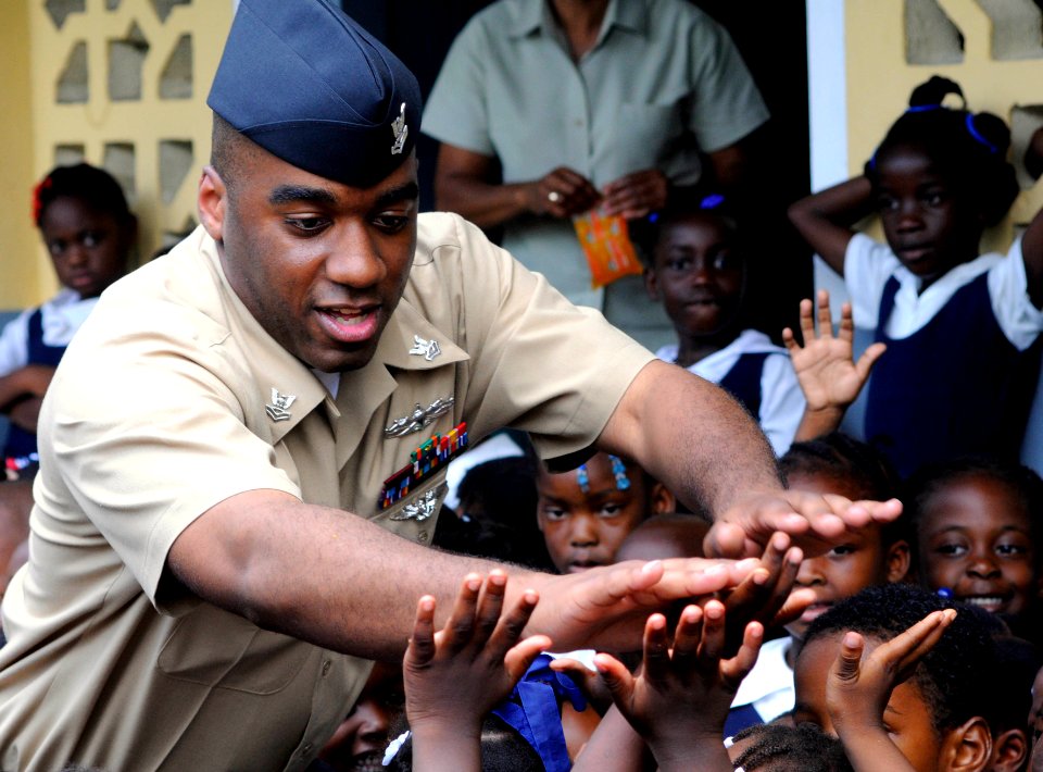 US Navy 100512-N-4971L-232 A Sailor plays with children during a Project Handclasp donation
