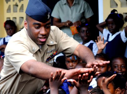 US Navy 100512-N-4971L-232 A Sailor plays with children during a Project Handclasp donation photo