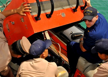 US Navy 100514-N-7643B-054 Chief Warrant Officer Christopher Smasne discusses the Zodiac small boat engine layout with Royal Thai Navy sailors