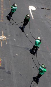 US Navy 100512-N-4236E-160 Sailors carry an arresting cable across the flight deck of the aircraft carrier USS Dwight D. Eisenhower (CVN 69)