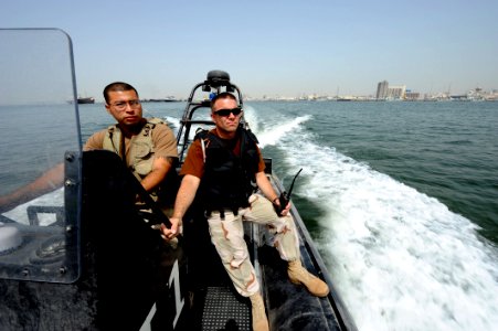 US Navy 100512-N-6463B-023 Chief Master-at-Arms Brandon Parks and Boatswain's Mate 2nd Class Hugo Escobar maintain port security along U.S. and coalition force piers in Bahrain photo
