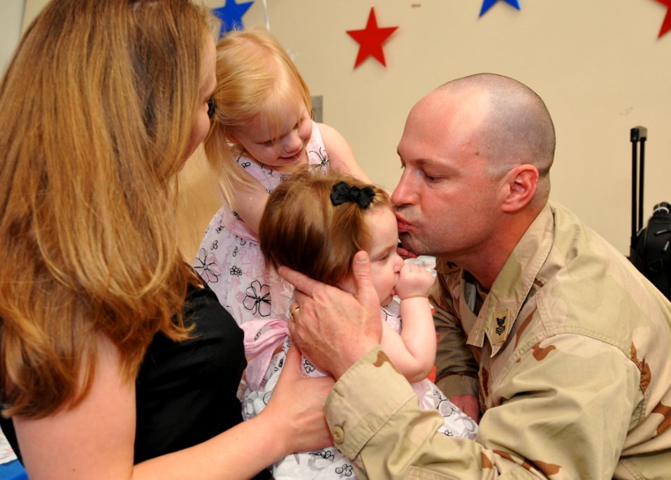 US Navy 100512-N-9095H-022 Master-At-Arms 1st Class Jason Morris, assigned to Maritime Expeditionary Security Squadron (MESF) 4, kisses his daughter after seeing her for the first time