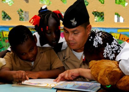 US Navy 100512-N-4971L-368 A Sailor plays with children during a Project Handclasp donation photo