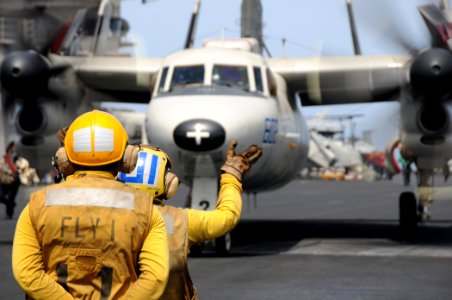 US Navy 100518-N-4236E-056 Aviation Boatswain's Mate (Handling) 2nd Class Bryant Simms and Aviation Boatswain's Mate (Handling) Airman Antoinette Corona direct an E-2C Hawkeye