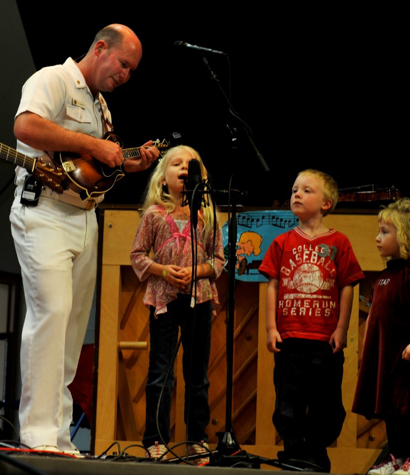 US Navy 100518-N-0773H-026 Chief Musician Patrick White assists an audience member from Carroll Manor Elementary School in a performance On Grandpa's Farm