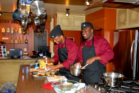 US Navy 100513-N-0869H-013 Culinary Specialist 2nd Class Demontray Braswell, left, and Personnel Specialist 3rd Class Wendall Nelson prepare tomato brochette samples for patrons of Kitchen Engine, a local cooking products shop photo