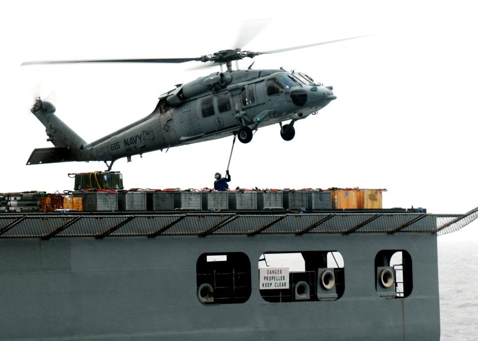 US Navy 100518-N-7908T-428 A Sailor assigned to the military Sealift Command dry cargo and ammunition ship USNS Lewis and Clark (T-AKE 1) attaches a load of ammunition to an MH-60S Sea Hawk helicopter