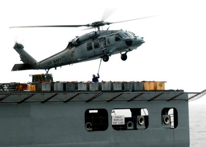 US Navy 100518-N-7908T-428 A Sailor assigned to the military Sealift Command dry cargo and ammunition ship USNS Lewis and Clark (T-AKE 1) attaches a load of ammunition to an MH-60S Sea Hawk helicopter