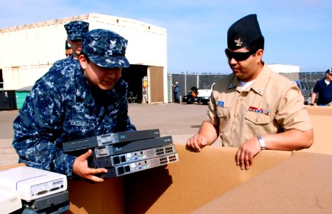 US Navy 100513-N-1926C-114 Information Systems Technicians 2nd Class Steffan Escobar and Jomar Romero drop off items at the E-Waste and Recyclable Appliance Turn-In event