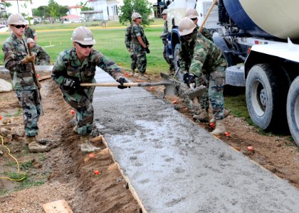 US Navy 100513-N-6357K-036 Seabees assigned to Naval Mobile Construction Battalion (NMCB) 7 distribute concrete for a sidewalk project at Naval Station Rota