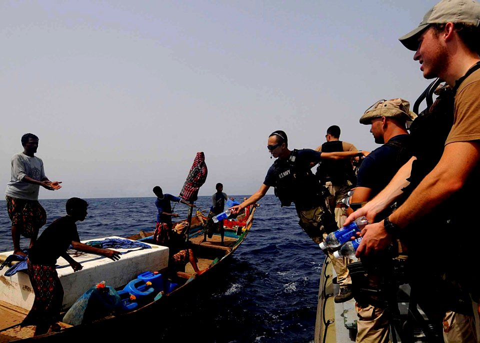 US Navy 100519-N-1082Z-074 Electronics Technician 2nd Class Patrick T. Huynh, long with other approach and visit team memberspass out bottled water to fishing dhow crew members