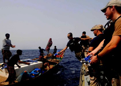 US Navy 100519-N-1082Z-074 Electronics Technician 2nd Class Patrick T. Huynh, long with other approach and visit team memberspass out bottled water to fishing dhow crew members photo