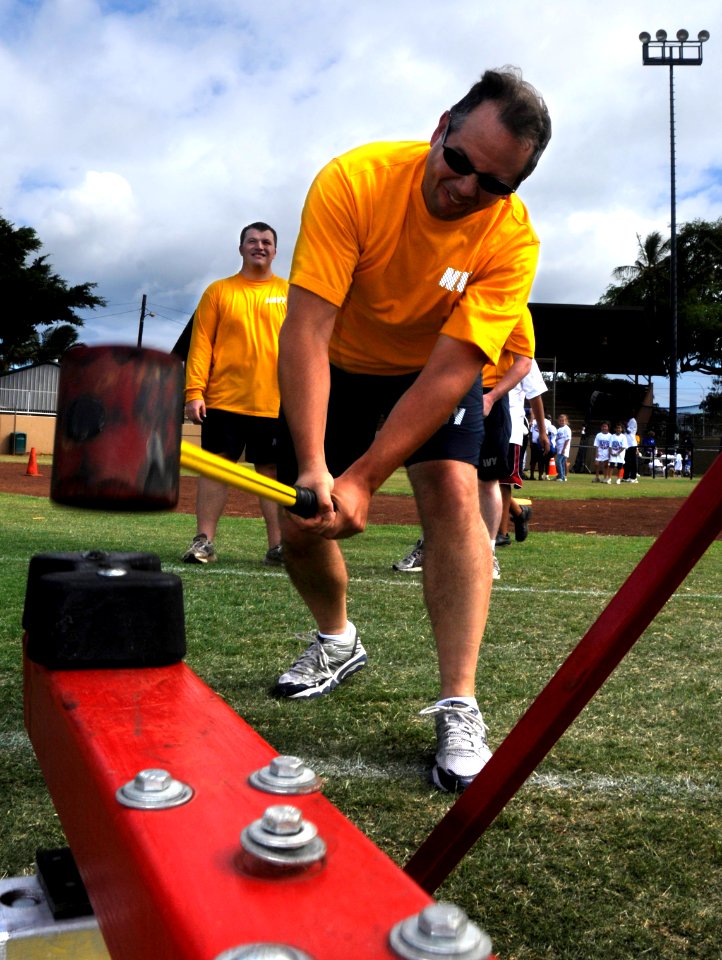 US Navy 100519-N-7498L-162 Cryptologic Technician (Maintenance) 1st Class Stephen Huber swings a sledgehammer at the high striker during a Morale, Welfare and Recreation Fitness and Wellness Fair