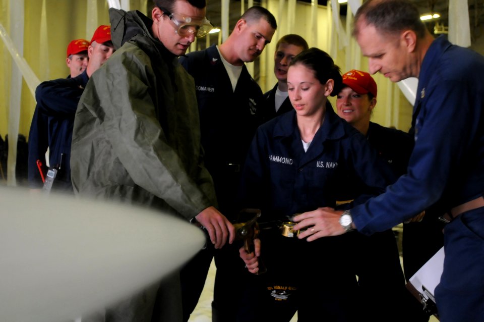 US Navy 100518-N-5503T-028 Damage Controlman Fireman Recruit Kim Hammond aims the nozzle of a fire hose