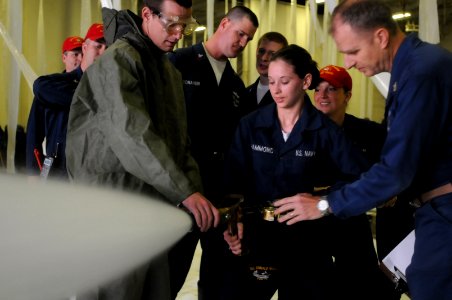 US Navy 100518-N-5503T-028 Damage Controlman Fireman Recruit Kim Hammond aims the nozzle of a fire hose