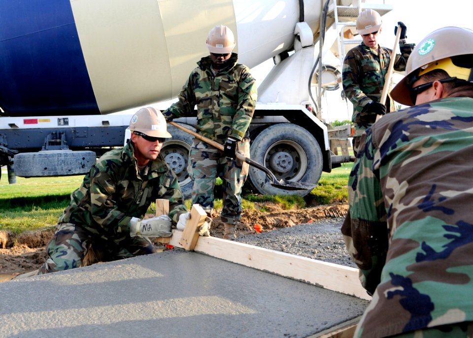US Navy 100514-N-6357K-042 Seabees assigned to Naval Mobile Construction Battalion (NMCB) 7 use a screed board to smooth and remove excess concrete at a sidewalk project at Naval Station Rota