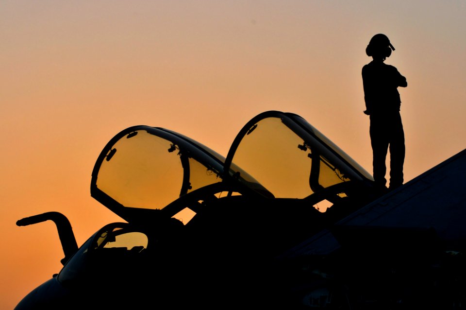 US Navy 100514-N-3595W-002 A sailor assigned to the Patriots of Electronic Attack Squadron (VAQ) 140 watches the sunset on top of an EA-6B Prowler aboard the aircraft carrier USS Dwight D. Eisenhower (CVN 69)