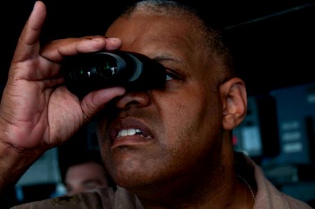 US Navy 100520-N-5712P-095 Rear Adm. Sinclair Harris, commander of Expeditionary Strike Group (ESG) 5, observes a training evolution on the bridge aboard the multipurpose amphibious assault ship USS Nassau (LHA 4) photo