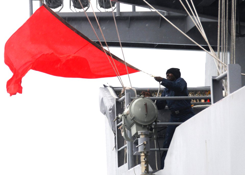 US Navy 100518-N-8913A-418 Quartermaster Seaman Brittany N. Raines lowers a bravo flag after a vertical replenishment