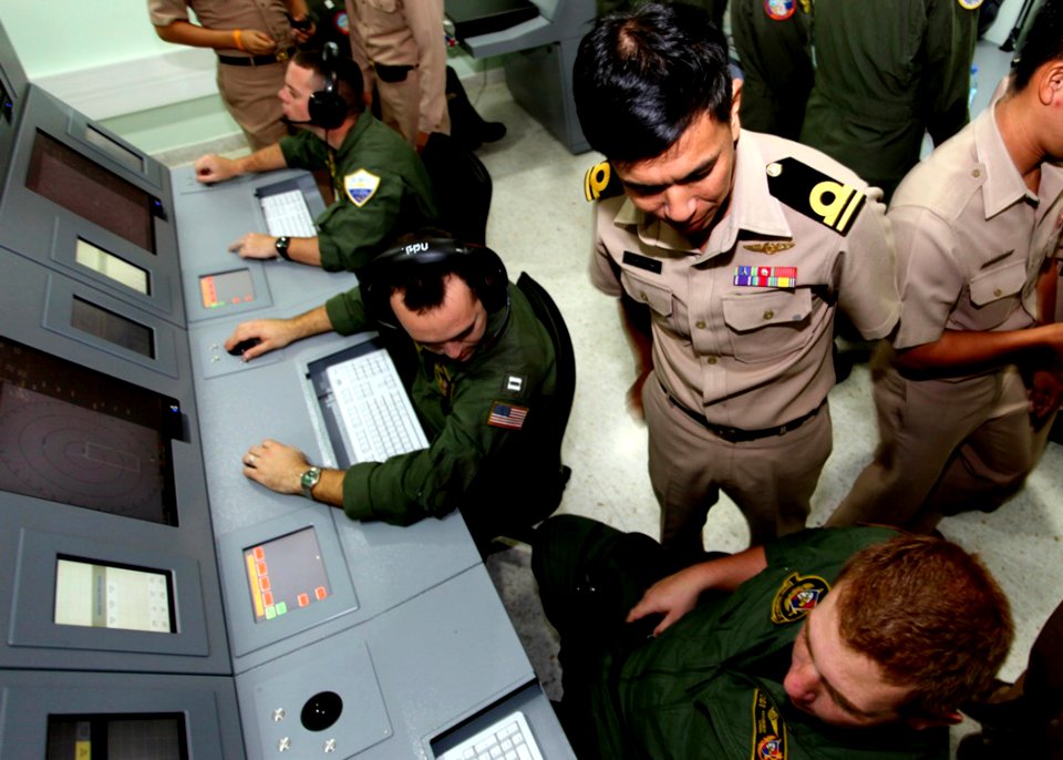 US Navy 100514-N-8093C-132 A Royal Thai Navy sailor overlooks Naval Air Crewman (Operator) 2nd Class Jacob Hobbs as he operates a Thai P-3C Orion anti-submarine warfare simulator