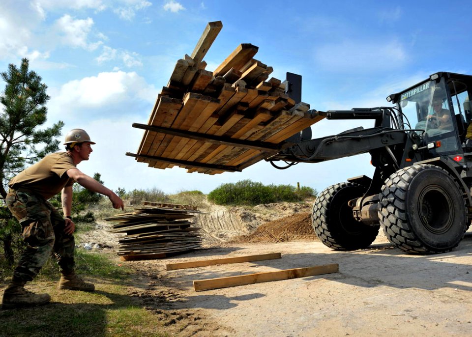 US Navy 100518-N-0000C-001 Builder 3rd Class Justin O'Donnell guides Equipment Operator 3rd Class Zachary Bunter as he operates a caterpillar 924G bucket loader