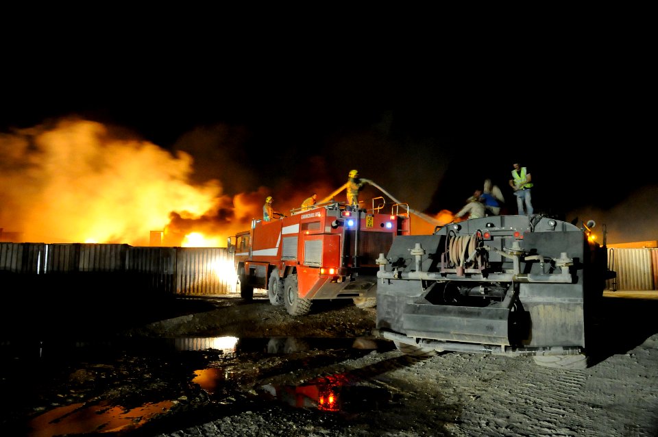 US Navy 100517-N-0475R-800 Seabees assigned to Naval Mobile Construction Battalion (NMCB) 5 and fire crews from Camp Leatherneck and Camp Bastion help fight a fire at a supply area at Camp Leatherneck, Afghanistan