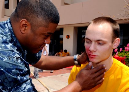 US Navy 100518-N-6326B-032 Hospital Corpsman 1st Class Ricardo A. Blake assesses facial burns and abrasions on the face of Hospital Corpsman Seaman Patrick T. Mesey during the annual statewide Golden Guardian drill photo