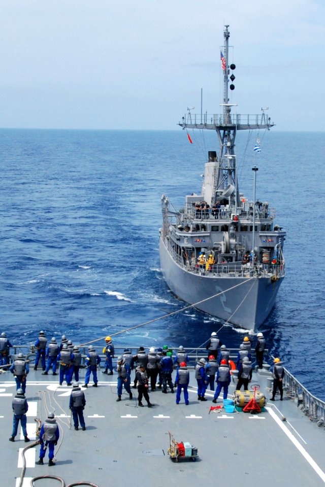 US Navy 100522-N-0000X-824 The mine countermeasures ship USS Defender (MCM 2) receives lines from the Japan Maritime Self-Defense Force minesweeping support vessel JS Uraga (MST 463)