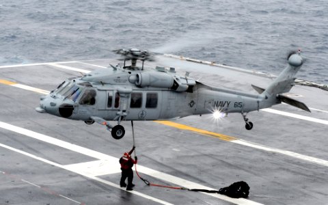 US Navy 100518-N-8913A-308 Sailors assigned to USS George H.W. Bush (CVN 77) attach replenishment nets to an MH-60S Sea Hawk helicopter