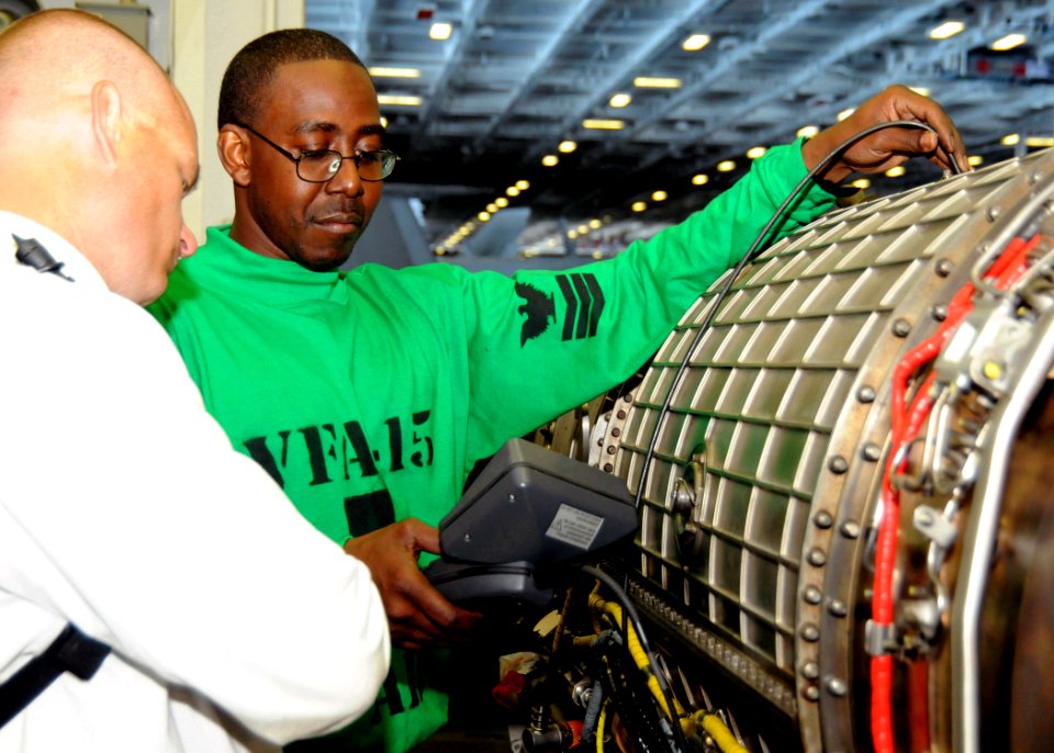 US Navy 100520-N-8913A-156 Aviation Machinist's Mate 1st Class Horace R. Cyrus performs an inspection on a jet engine inside the jet shop aboard USS George H.W. Bush (CVN 77)
