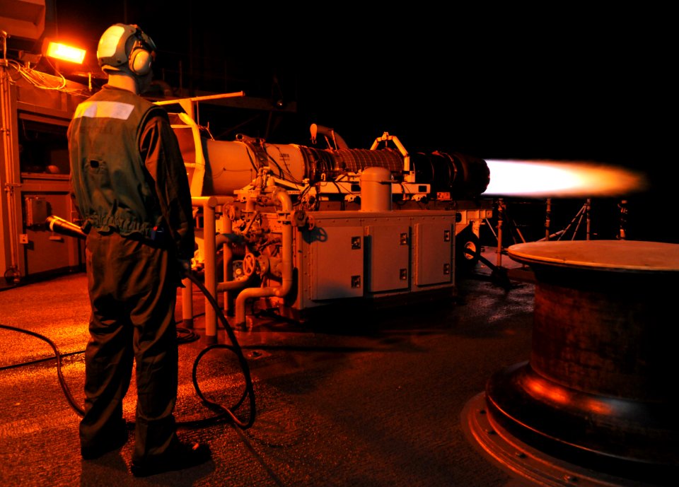 US Navy 100522-N-4516G-101 Aviation Machinist's Mate Airman Leo M. Barth stands by with a fire extinguisher nozzle during a test cell engine run on an F-A-18 Hornet engine aboard the aircraft carrier USS Enterprise (CVN 65)