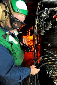 US Navy 100522-N-4516G-056 Aviation Machinist's Mate 1st Class Wade A. Carr troubleshoots an electrical junction panel for a test cell engine run on an F-A-18 engine aboard the aircraft carrier USS Enterprise (CVN 65)