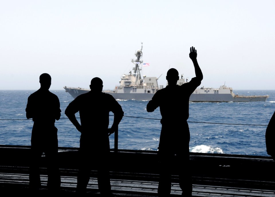 US Navy 100523-N-4236E-209 The Sailors aboard the aircraft carrier USS Dwight D. Eisenhower wave as the guided-missile destroyer USS Farragut (DDG 99) passes the ship