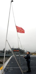 US Navy 100524-N-6676S-010 Aviation Boatswain's Mate (Handling) Airman Tracy Chambers, from Bloomington, Ind., takes down the Navy jack from the flight deck of the multi purpose amphibious assault ship USS Iwo Jima (LHD 7)