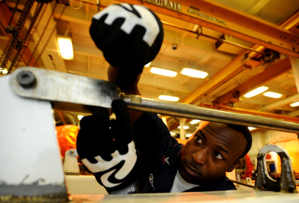 US Navy 100521-N-4516G-007 Aviation Machinist's Mate 2nd Class Curtis L. Gibson rigs a safety wire to the engine run trailer aboard the aircraft carrier USS Enterprise (CVN 65)