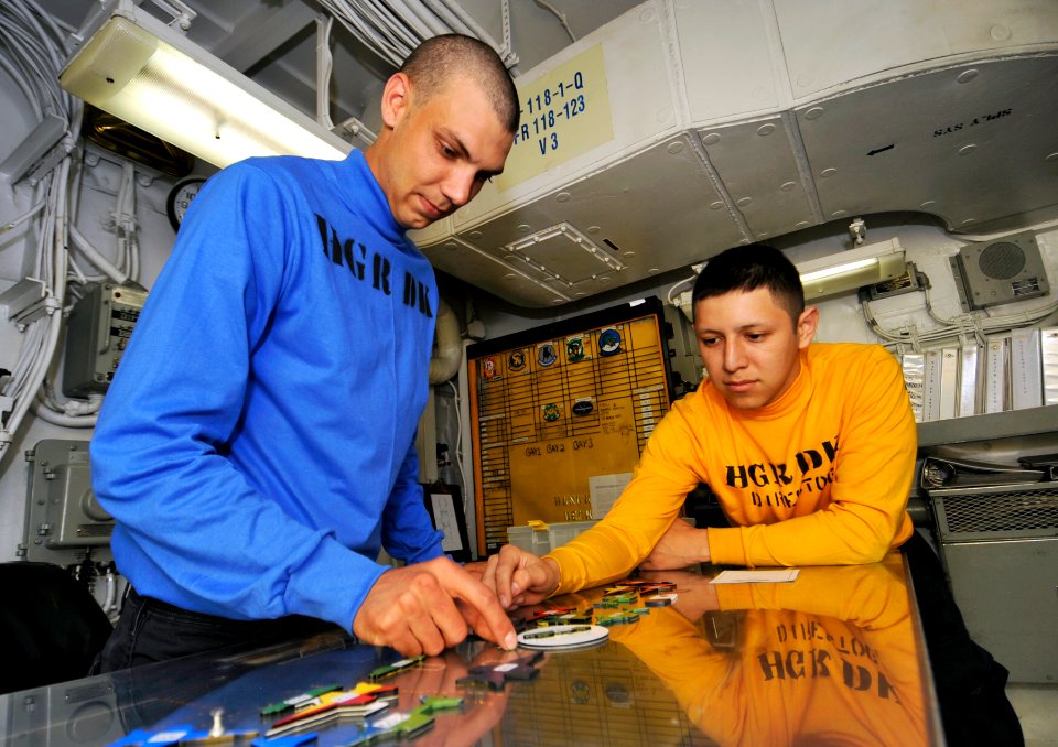 US Navy 100525-N-6003P-085 Aviation Boatswain's Mate (Handling) Airman Shane Freeman and Aviation Boatswain's Mate (Handling) 3rd Classs Ray Amaya plan aircraft movement on the deck control room Ouija board