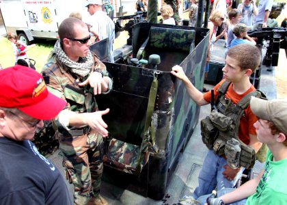 US Navy 100522-N-4205W-006 A special warfare combatant-craft crewmen assigned to Special Boat Team 22 explains the weapons aboard the special operations craft Riverine during the annual Trail of Honor photo