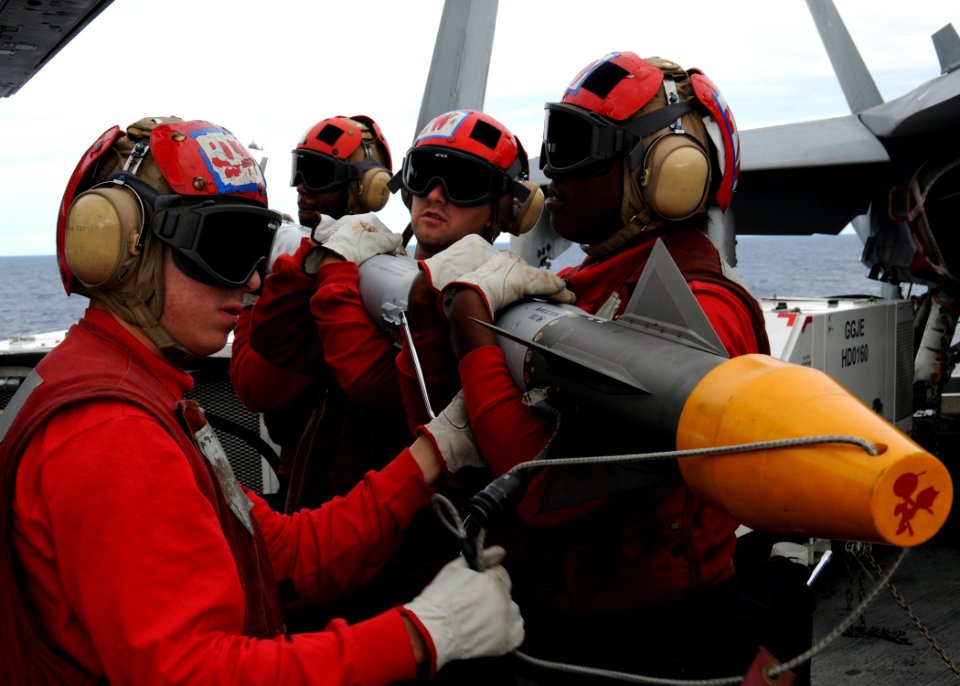 US Navy 100522-N-6509M-107 Sailors assigned to the weapons department of Strike Fighter Squadron (VFA) 31 prepare a missile before loading it onto an F-A-18E