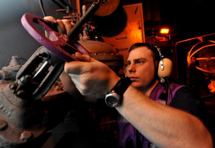 US Navy 100522-N-4516G-007 Aviation Boatswain's Mate (Fuels) Airman Jeffrey A. Schubert opens a gate-valve discharge to fuel an F-A-18 Hornet engine for a test cell engine run aboard the aircraft carrier USS Enterprise (CVN 65)