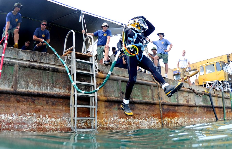 US Navy 100525-N-0413B-012 Brick Bradford, a retired Master Diver assigned to Joint POW-MIA Personnel Accounting Command (JPAC), jumps off a barge for a dive