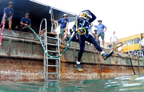 US Navy 100525-N-0413B-012 Brick Bradford, a retired Master Diver assigned to Joint POW-MIA Personnel Accounting Command (JPAC), jumps off a barge for a dive