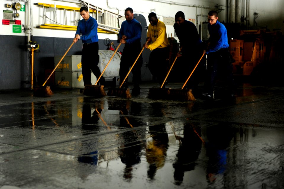 US Navy 100523-N-6604E-187 Sailors aboard the aircraft carrier USS Dwight D. Eisenhower (CVN 69)use scrub brushes to clean the deck in the hangar bay