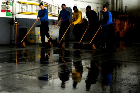 US Navy 100523-N-6604E-187 Sailors aboard the aircraft carrier USS Dwight D. Eisenhower (CVN 69)use scrub brushes to clean the deck in the hangar bay