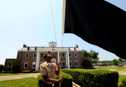 US Navy 100524-N-5328N-633 Cryptologic Technician (Technical) Seaman Antron Johnson-Gray, a student at the Center for Information Dominance Corry Station, raises the black flag for the first time in 2010 photo